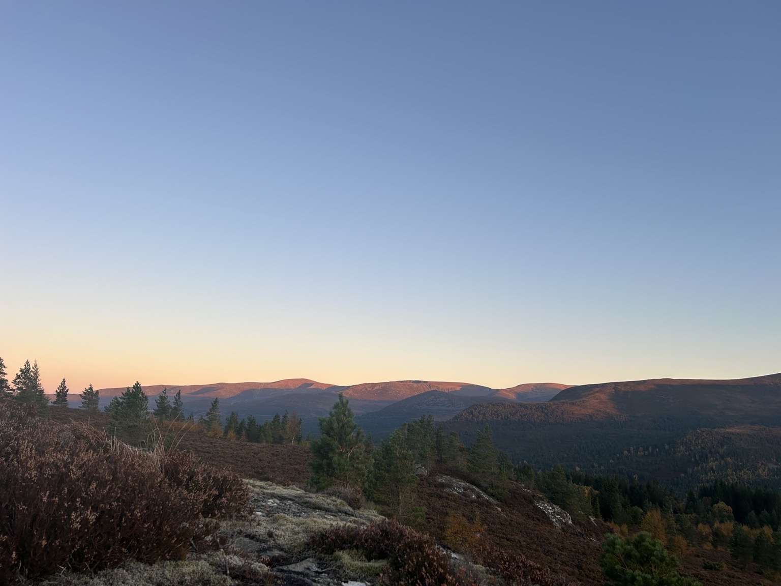 Low-angle light crossing peatland and hills towards the Cairngorms
